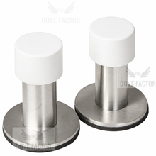 Load image into Gallery viewer, Two stainless steel and white plastic door stoppers on a white background with 'The Dove Factor' watermark.